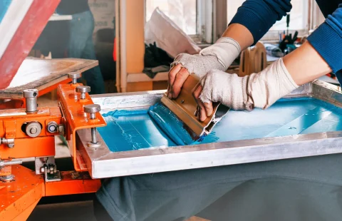 Serigrafi tezgahında manuel baskı yapan operatörler – serigrafi tezgahı kullanımı