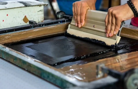 Serigrafi baskı kalıbı üzerinde rakle ile boya çekme işlemi
