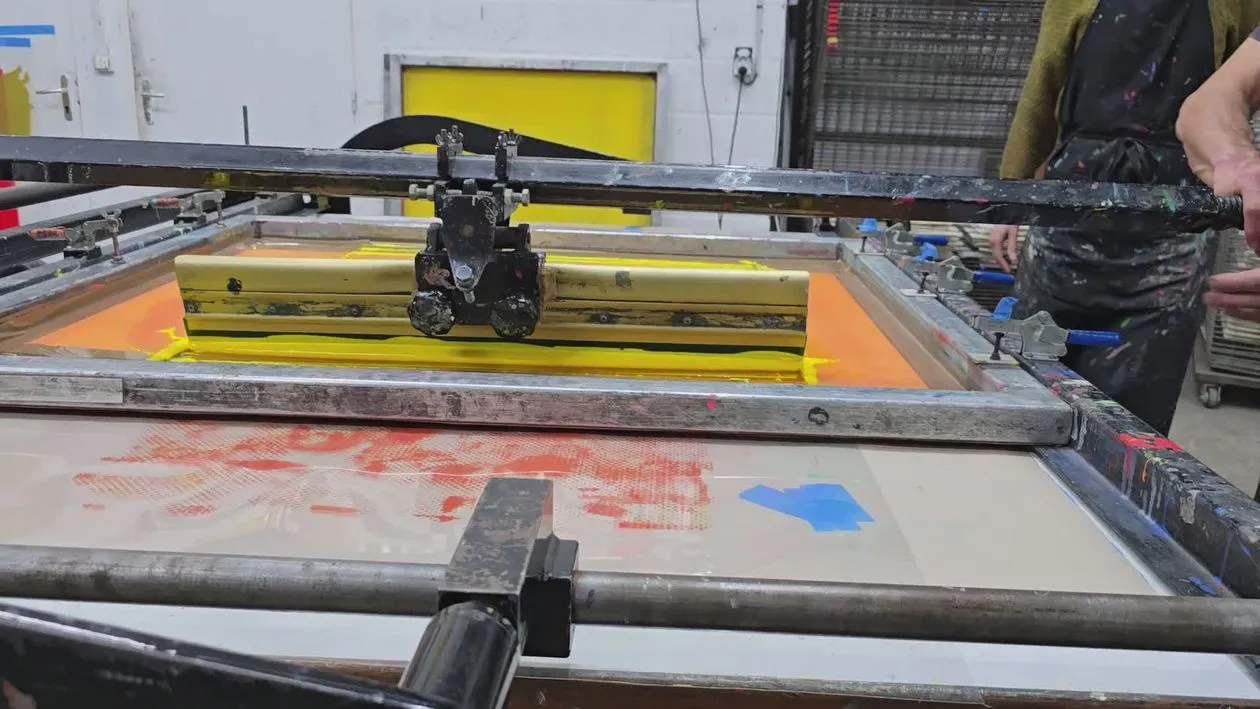 The image shows screen printing mesh pores clogged with paint, illustrating the question of why screen printing plates become clogged.